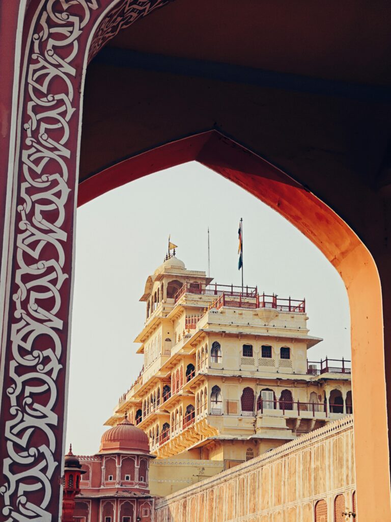 Stunning architectural view of the historic Jaipur City Palace framed by intricate arch.